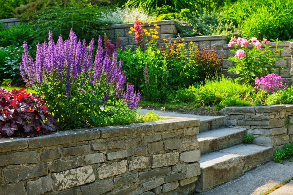 Photo of stone retaining wall and steps with colorful garden plantings