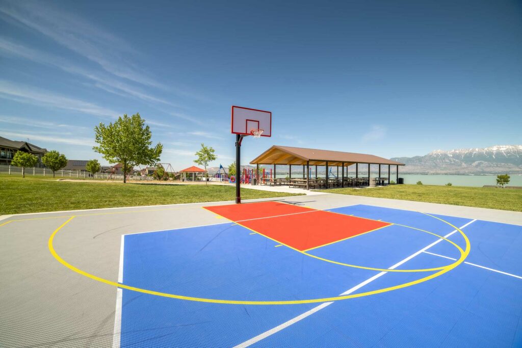 Photo of outdoor basketball court with playground in background